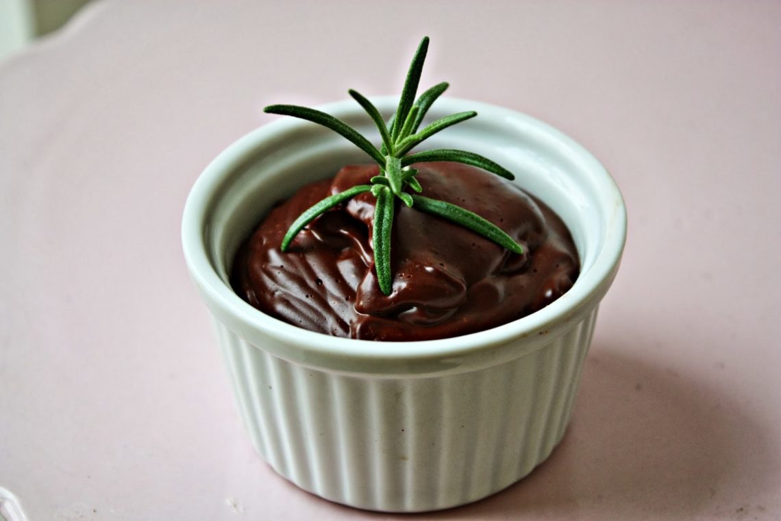 Selbstgemachter Schokoladen Pudding in einer kleinen Schale mit Rosmarin dekoriert