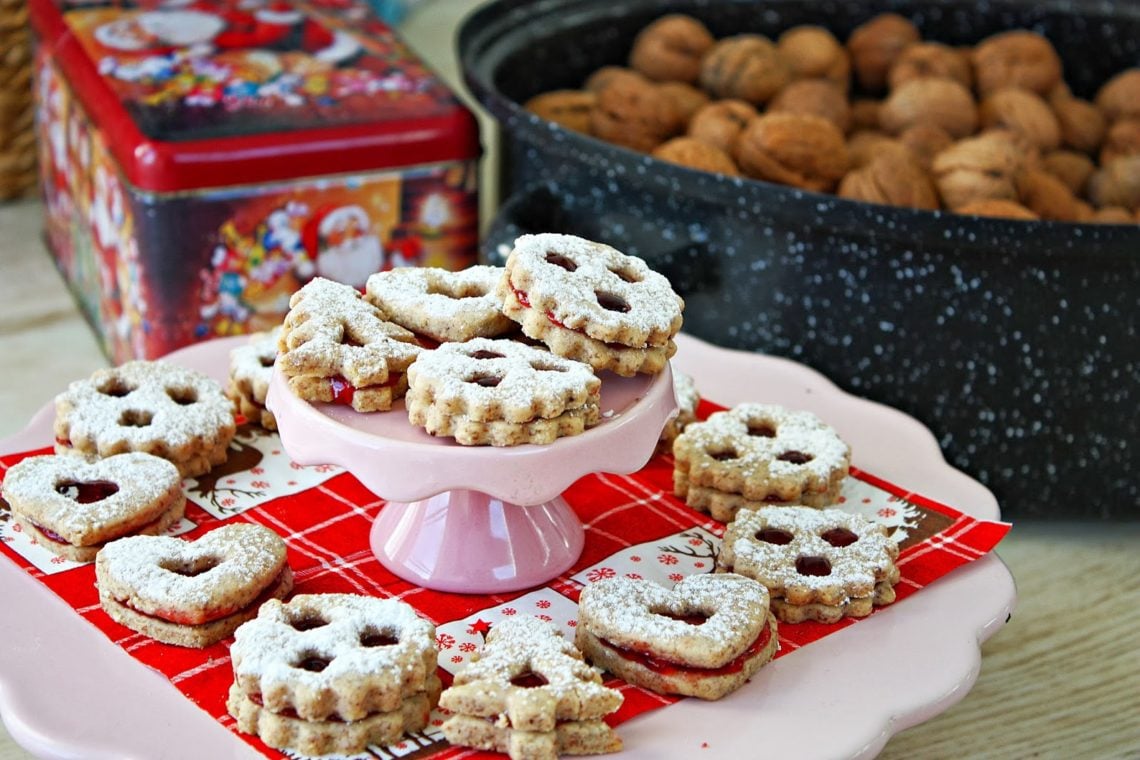 Austrian Linzer Cookies on a cookies stand with cookie tins in the background