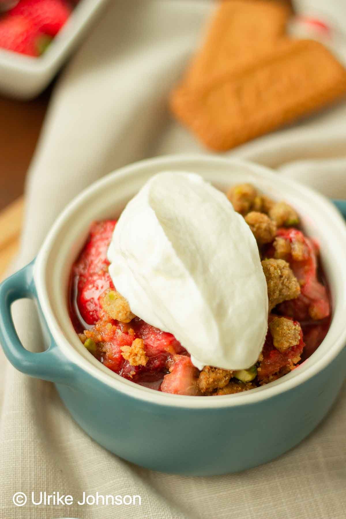 perfect Strawberry Rhubarb Crumble served with whipped cream in an individual baking dish