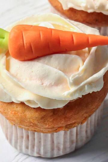 carrot banana muffins with quark frosting topped with a marzipan carrot