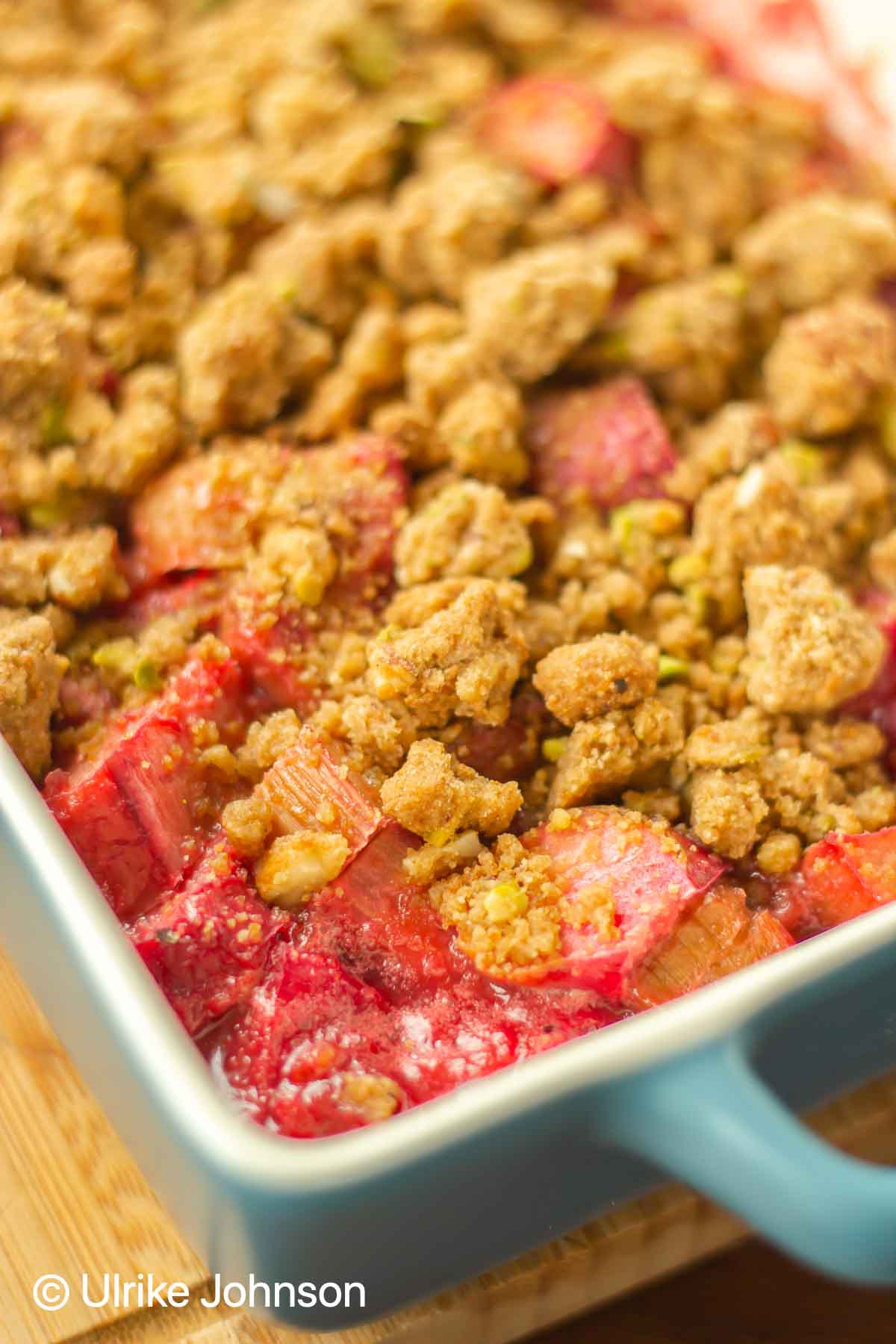 frisch gebackener Erdbeer Rhabarber Crumble mit Pistazien Streusel