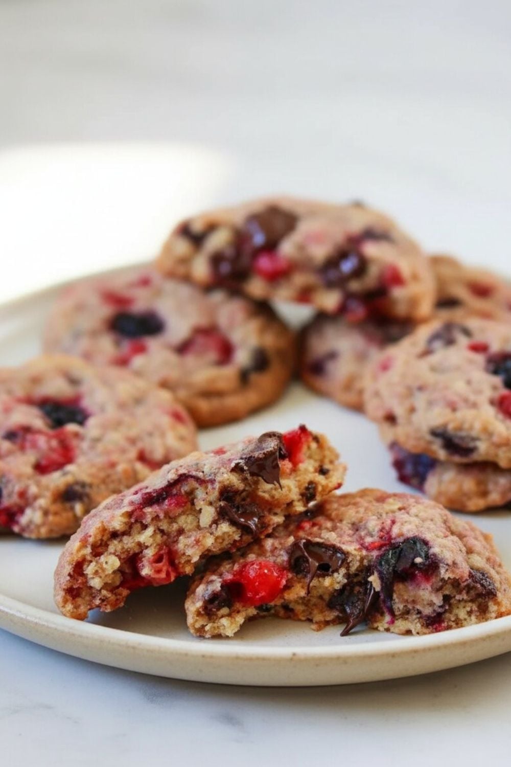 a plate with brown butter oatmeal cookies  with chocolate chips and raspberries