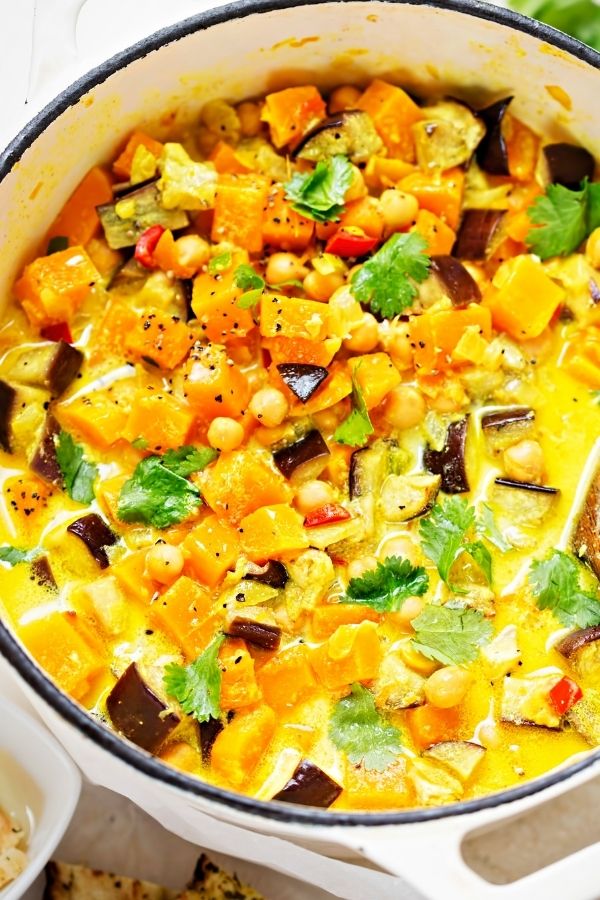a pot with simmering coconut chickpea curry with pumpkin 