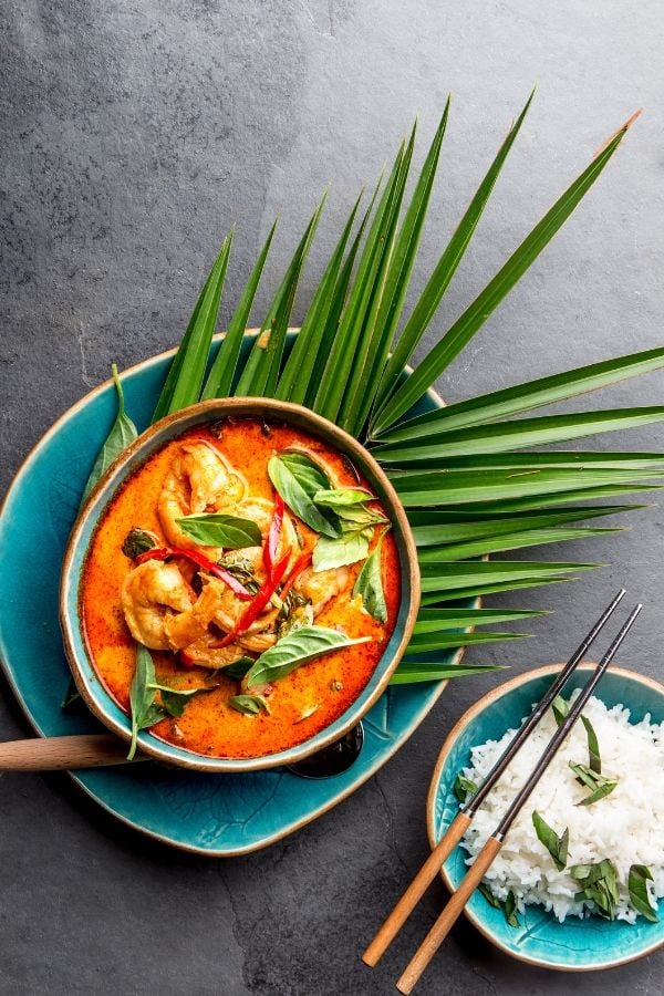 a bowl of creamy Paleo Brazilian Shrimp stew with coconut milk ( Moqueta ) served with a side of rice