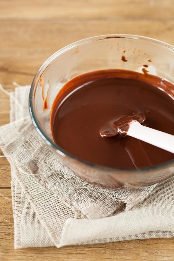 dunkle Schokolade wird mit heißer Milch vermischt für Schokoladeneis Rezept