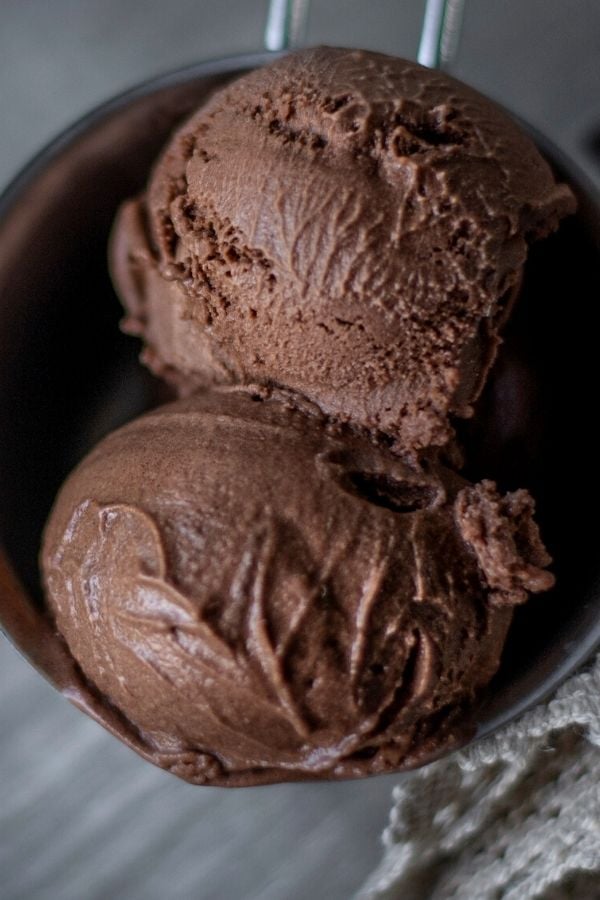 close up of two scoops of homemade dark chocolate ice cream with rum in a metal cup