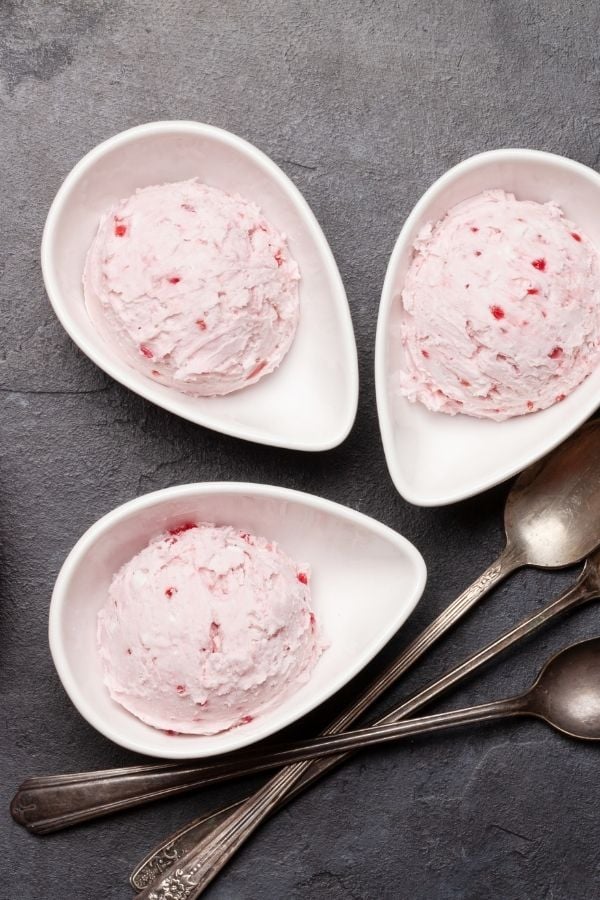three scoops of dairy-free raspberry coconut milk ice cream on individual plates
