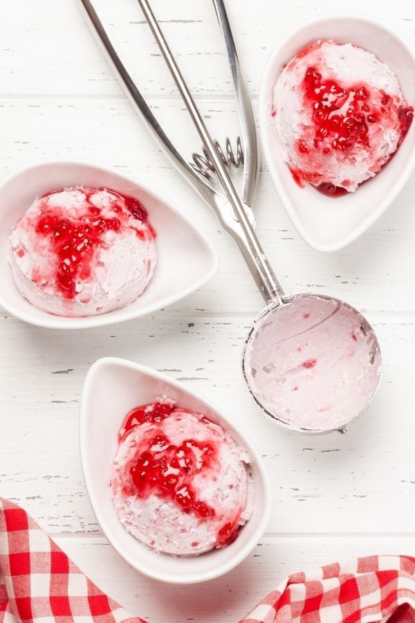 raspberry coconut ice cream being topped with raspberry compote 