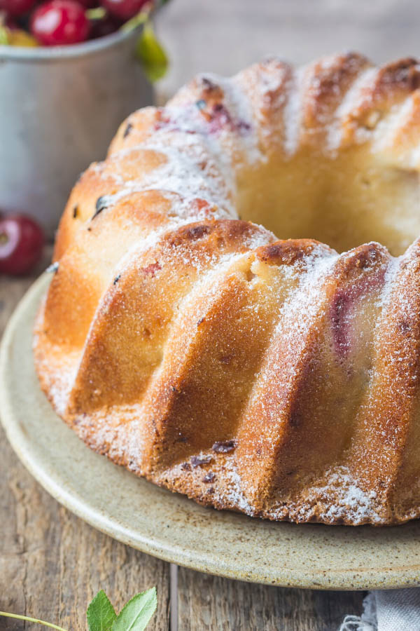 close-up side view of a Yogurt White chocolate cherry bundt cake dusted with icing sugar