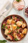 German Potato Salad with Warm Bacon Vinaigrette and caramelized onions in a rustic bowl