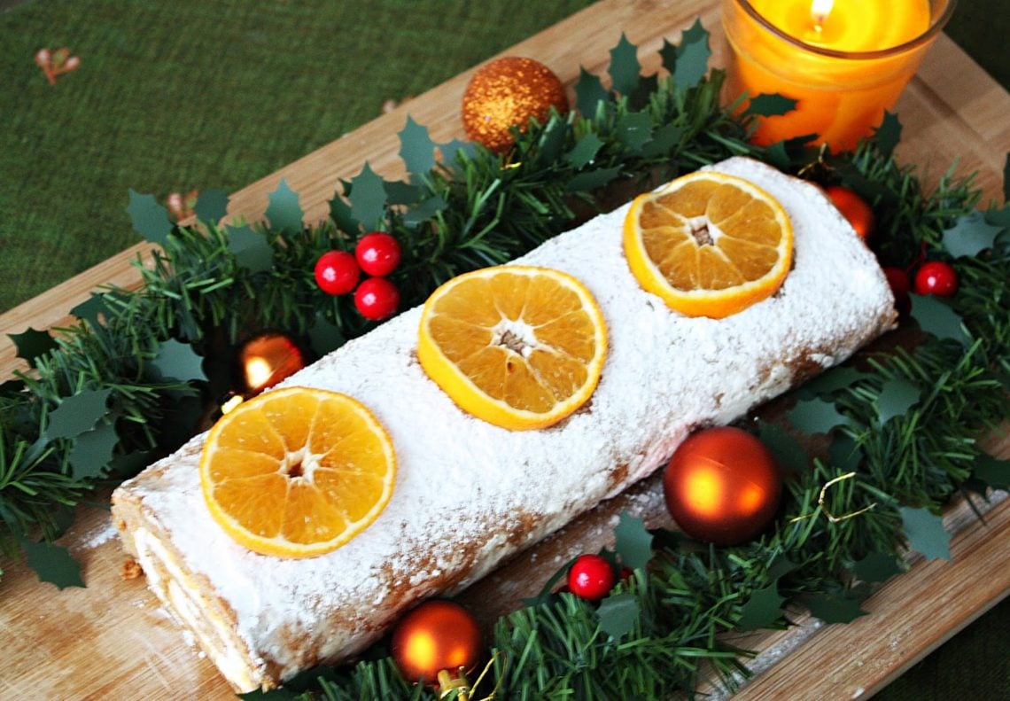 overhead shot of Gingerbread Cake Roll decorated with Orange slices and icing sugar