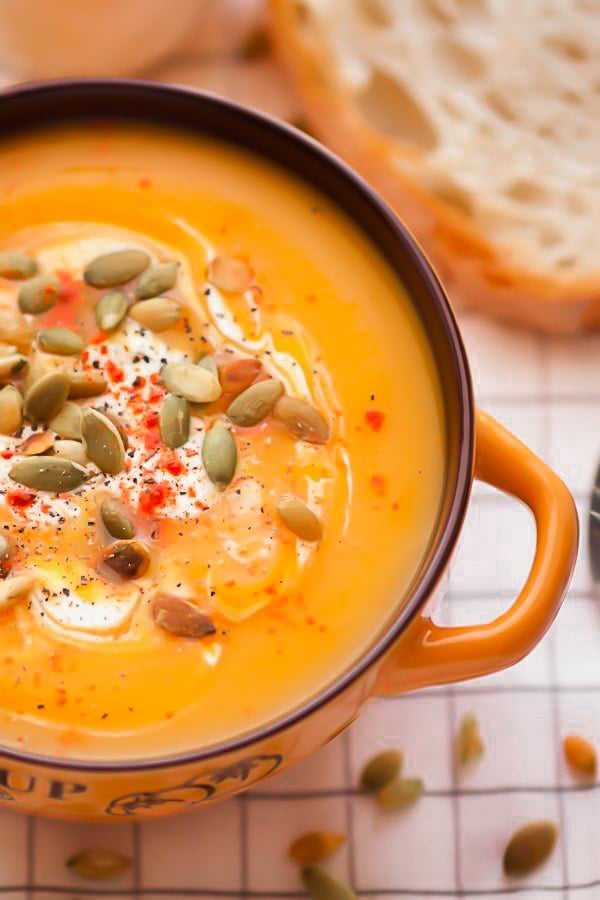 side view of a serving of easy healthy butternut squash soup with fresh orange juice and ginger