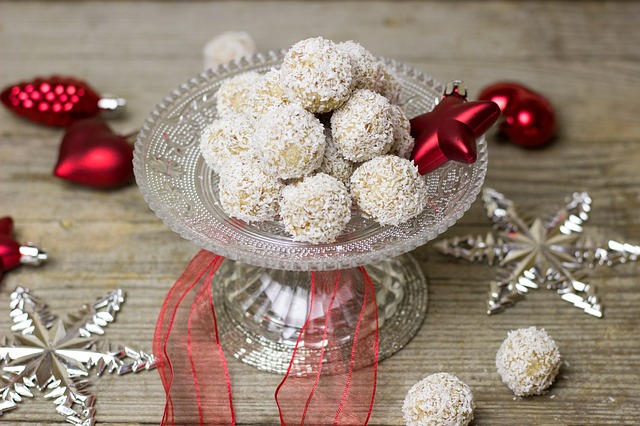 Spekulatius Pralinen mit weißer Schokolade und Kokosraspeln verziert auf einer weihnachtlichen Glas Etagere