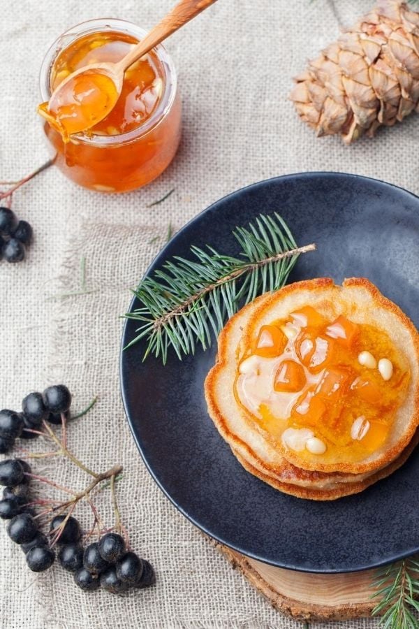 a stack of vegan almond milk pancakes topped with homemade orange rosemary marmalade
