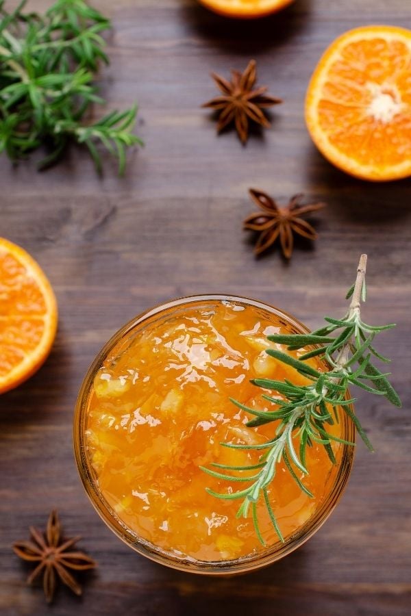 ein Glas selbstgemachte Orangenmarmelade mit Rosmarin 