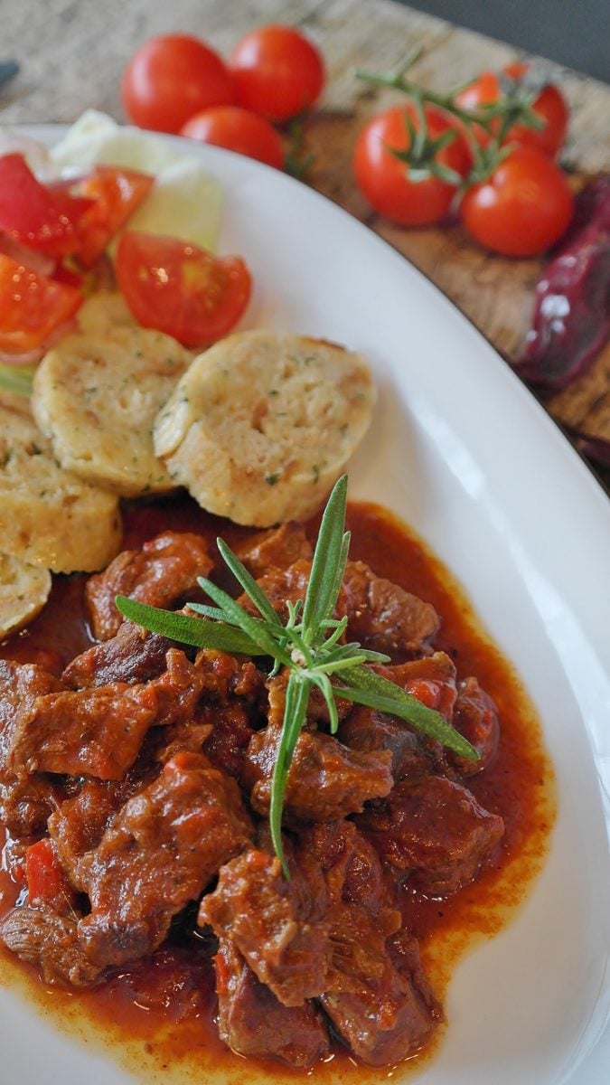 Traditional Beef Goulash served on a plate with sliced bread dumplings