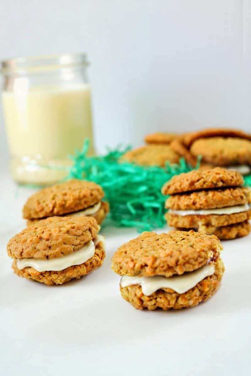 carrot cake cookies mit eierlikör fullung auf einem weissen Tisch mit einer Flasche eierlikör im Hintergrund 