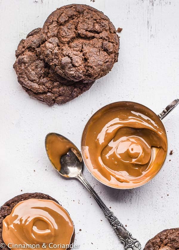 brownie cookies being sandwiched together with dulce de leche 