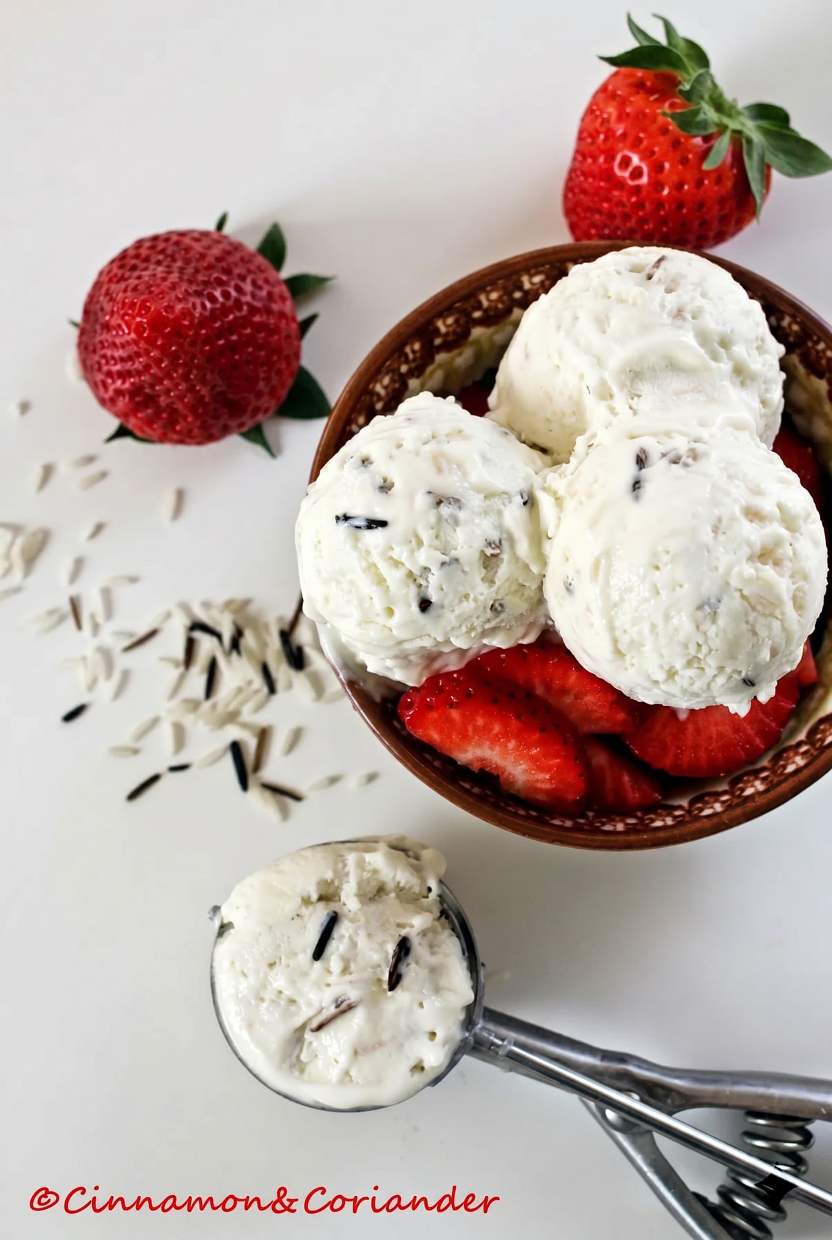 Reis Kokos Eis mit Kardamom Erdbeeren three scoops of coconut basmati rice ice cream with fresh strawberries