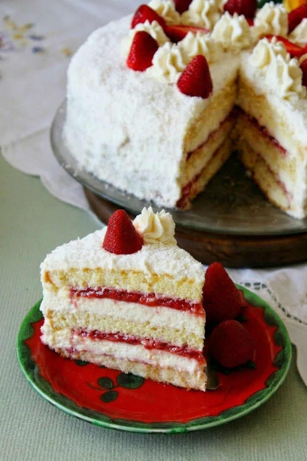 a slice of Coconut Strawberry Layer cake on a springtime table with fresh strawberries 