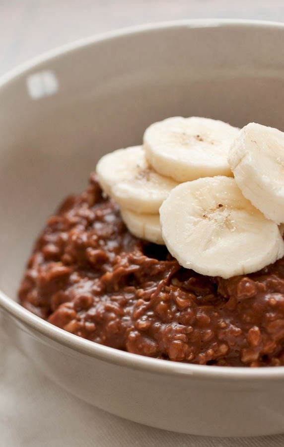 eine Schale veganes Schokoladen Porridge mit Kakao und Bananenscheiben dekoriert