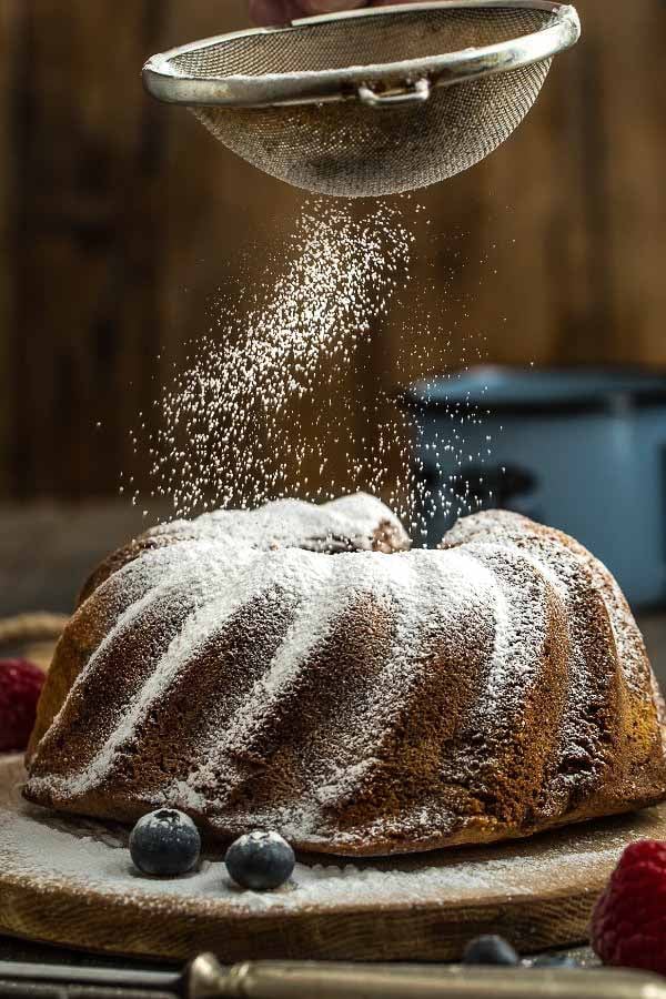 German Hazelnut Bundt Cake being dusted with icing sugar