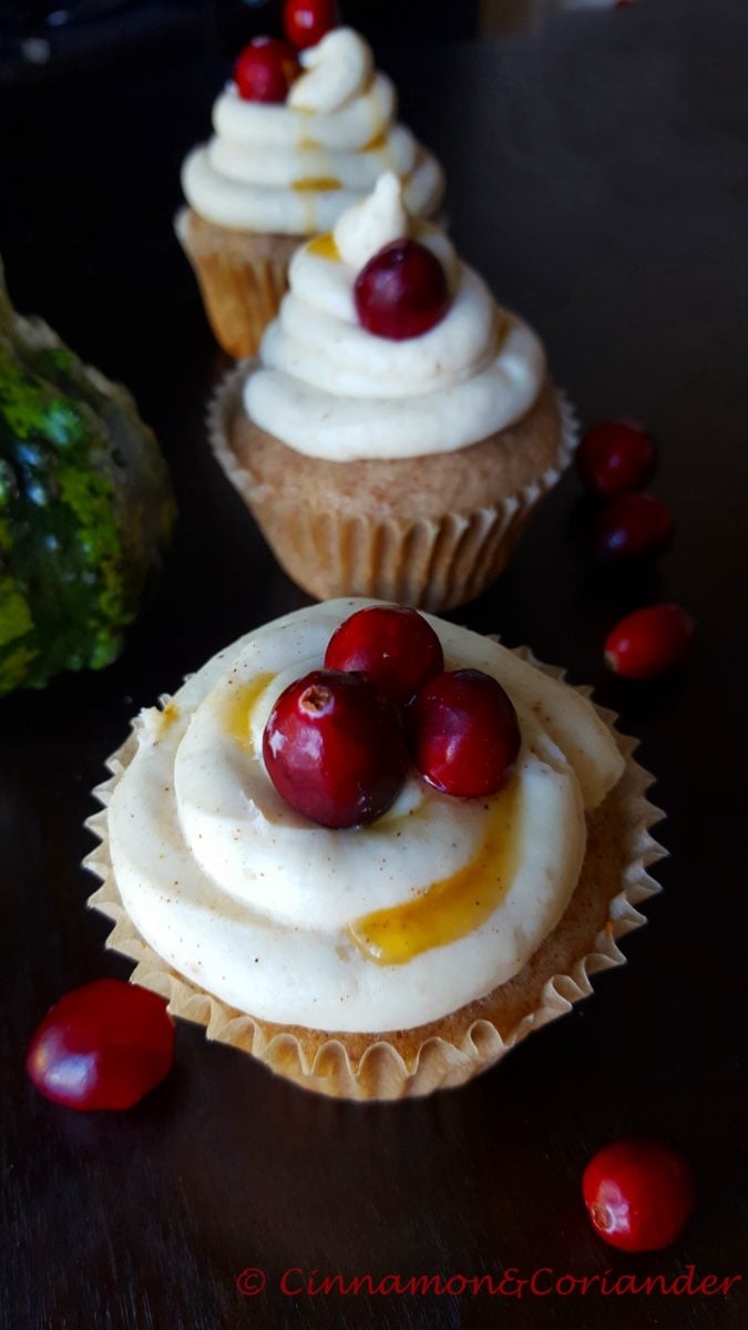 cranberry chai cupcakes with maple cream cheese frosting and fresh cranberries on top