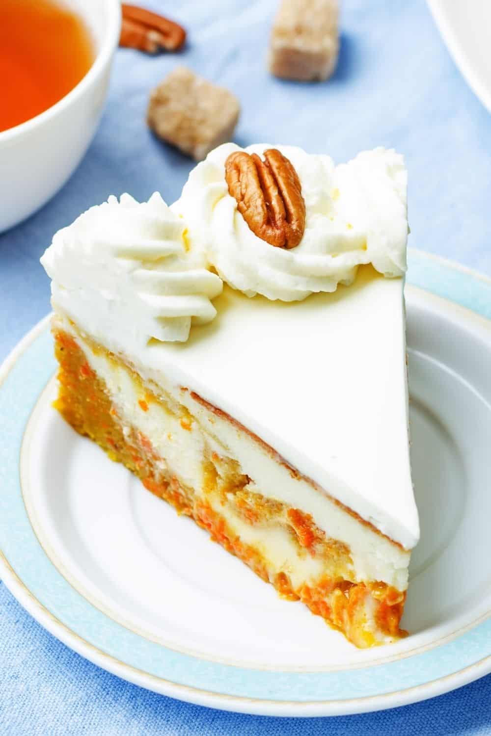 a slice of pumpkin cake swirl cheesecake topped with pecans and whipped cream.