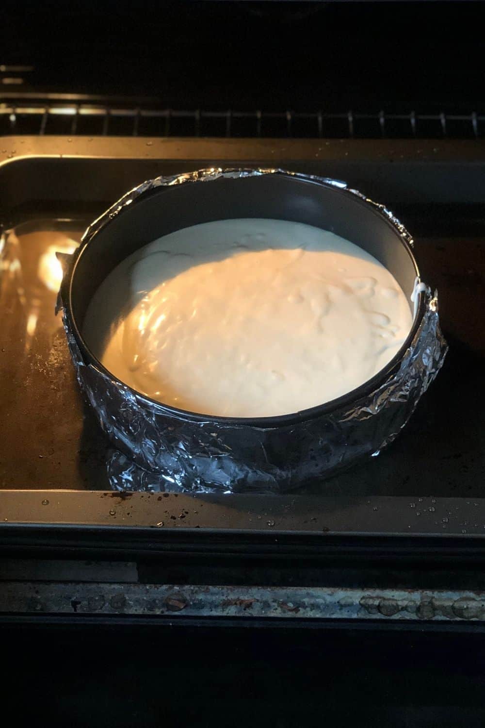 pumpkin cake cheesecake being baked in a water bath.