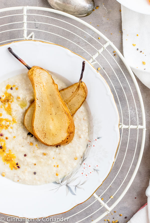 close-up of a bowl of Jamaican coconut milk porridge topped with pear slices and bee pollen