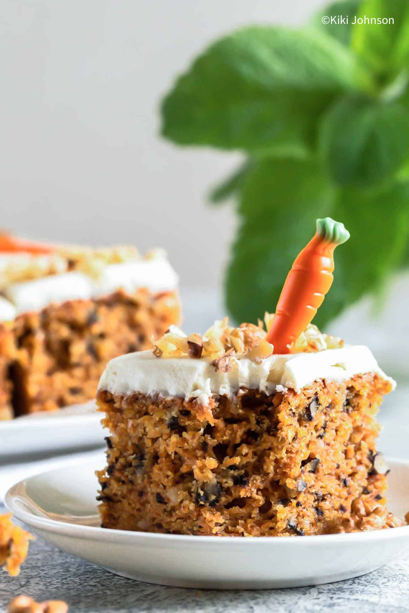 a piece of Canadian Carrot Cake topped with mascarpone icing and chopped nuts 