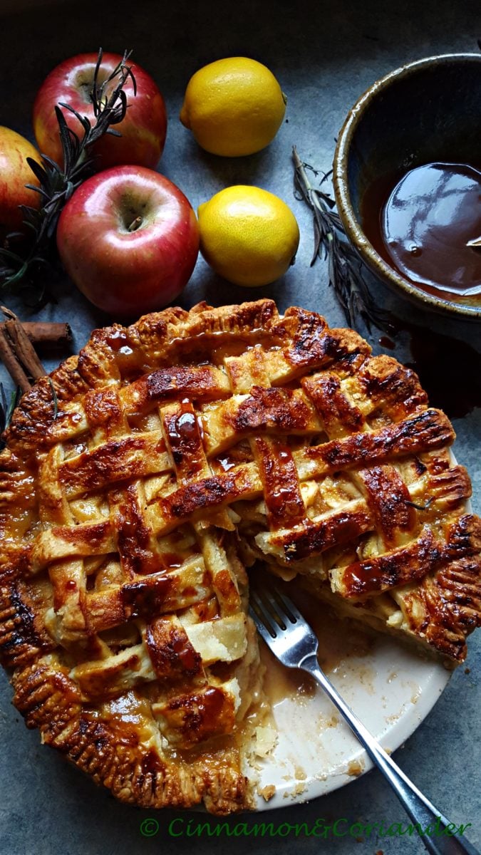 salted rosemary caramel apple pie with one slice cut out revealing the caramelized apple filling