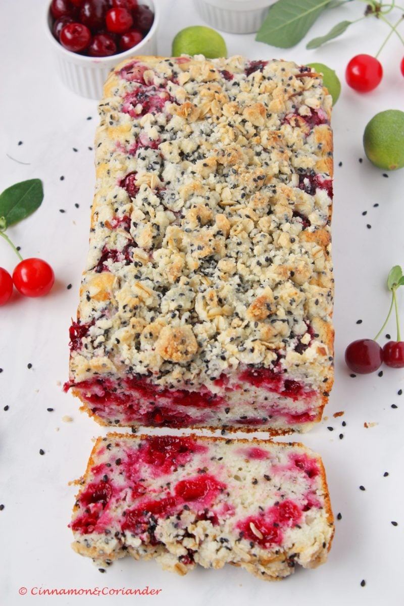 saftiger Kirschkuchen mit Joghurt und Sesam Streusel mit einen Stück angeschnitten.