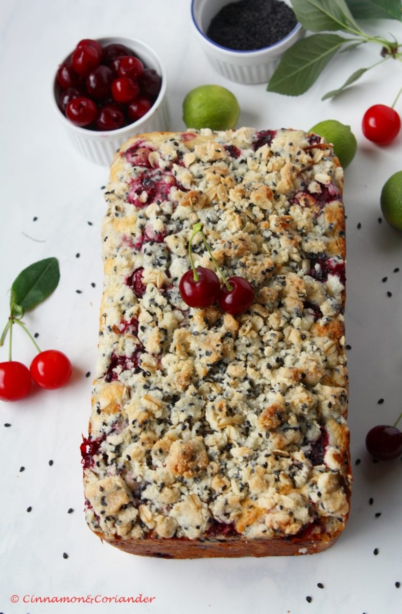 Kirschkuchen mit Joghurt und frischen Kirschen mit Sesam Streuseln auf einem Küchentisch.