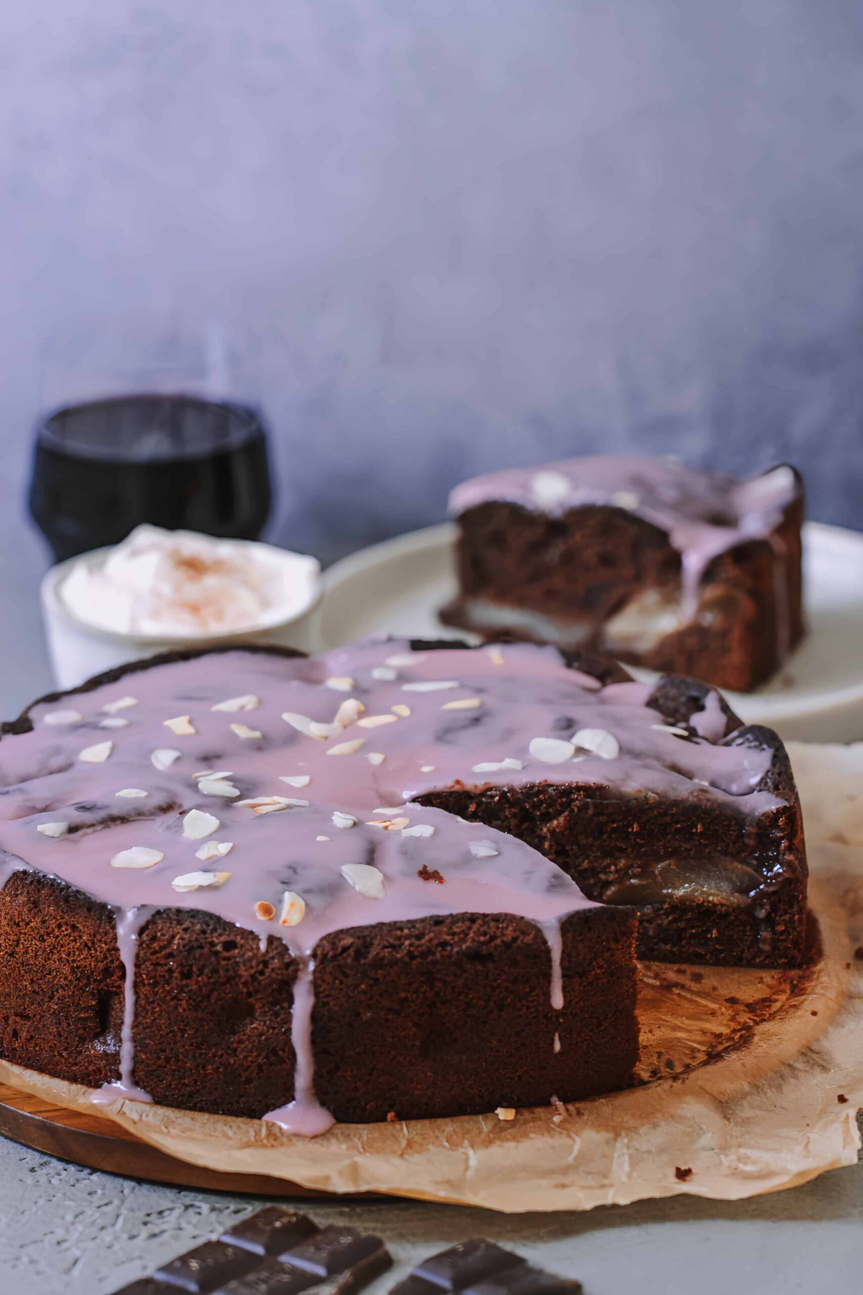 angeschnittener Rotweinkuchen mit Schokolade und Birnen auf einem Holzbrett 