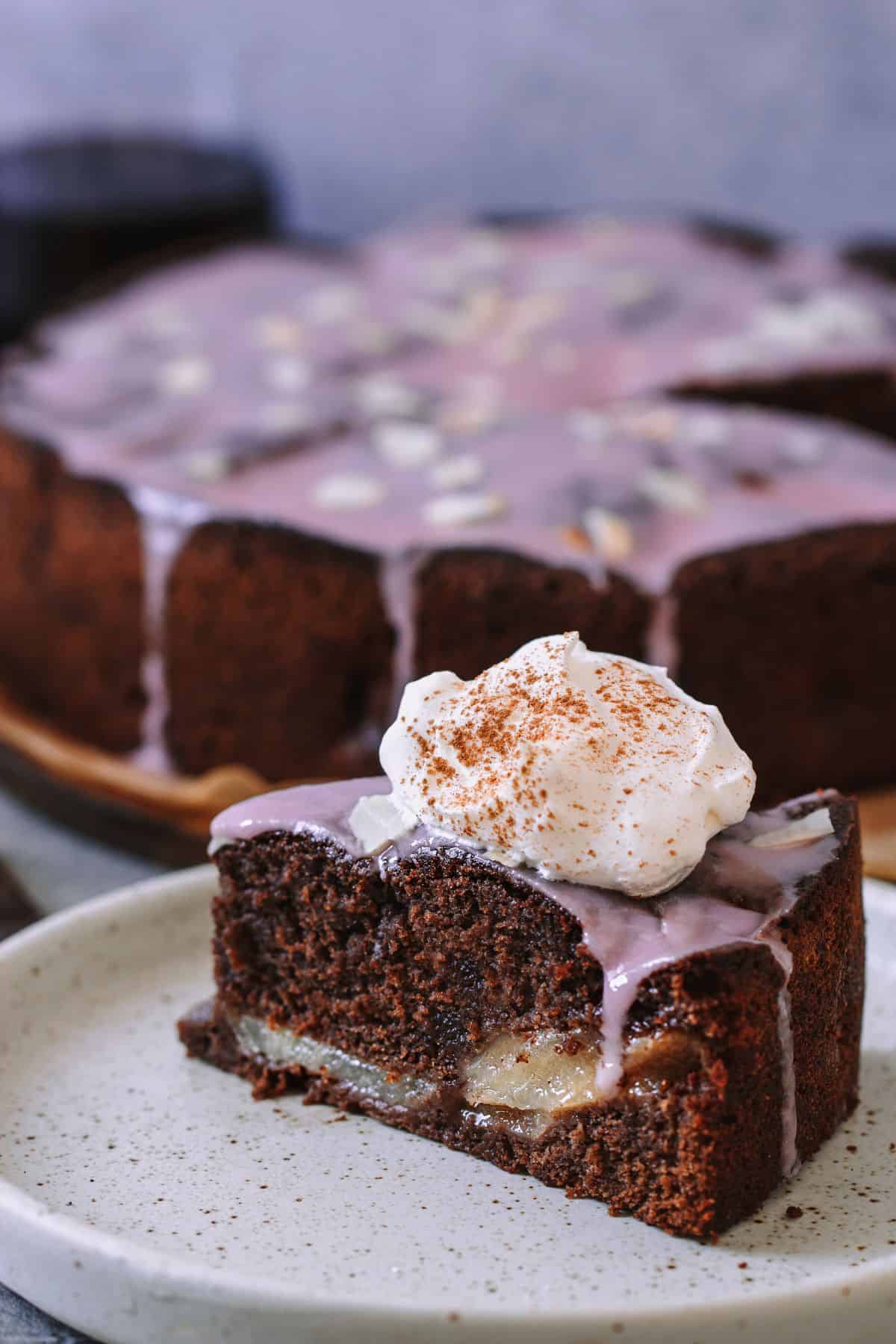 ein Stück von Omas Pfälzer Rotweinkuchen mit Birnen mit einem Klecks Sahne serviert 
