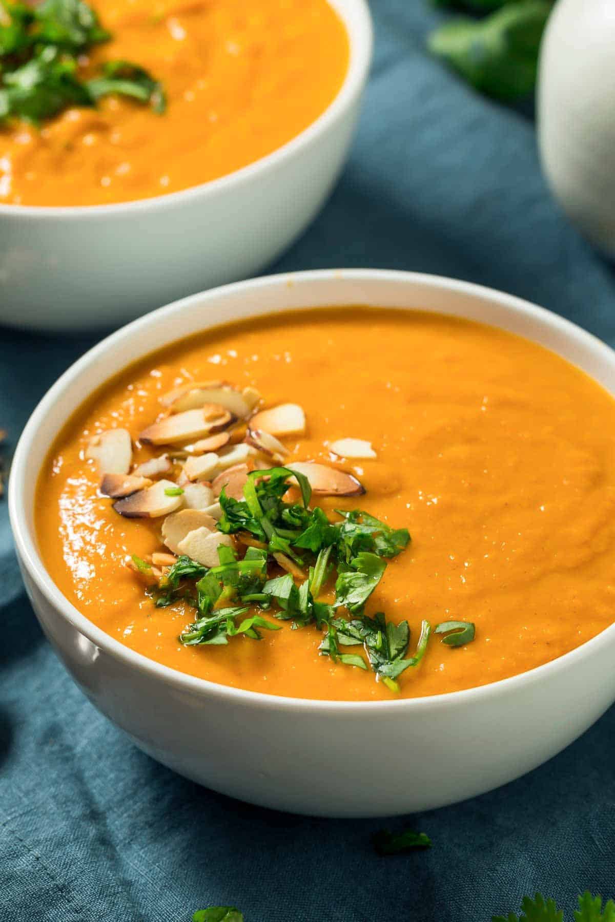 vegan sweet potato soup with coconut milk topped with cilantro and nuts