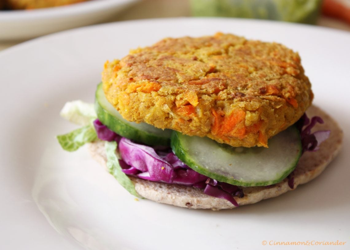 carrot chickpea burger patty on a whole wheat bun with veggies