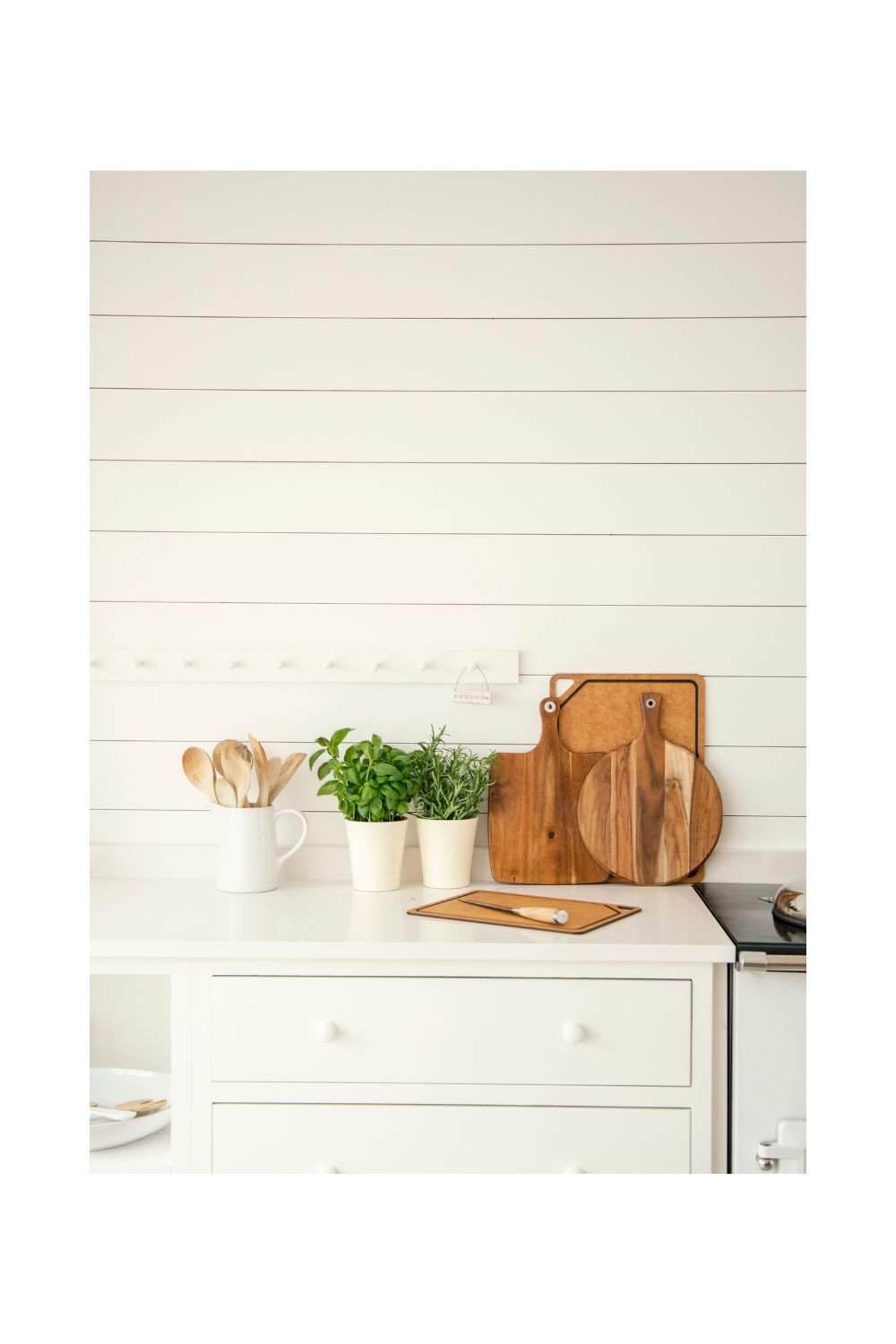 holz schneidebretter auf einer weissen Küchenkonsole