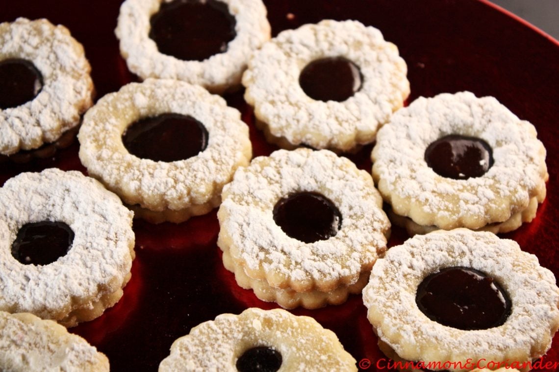 German Black Forest Sandwich Cookies (Spitzbuben) arranged on a red plate