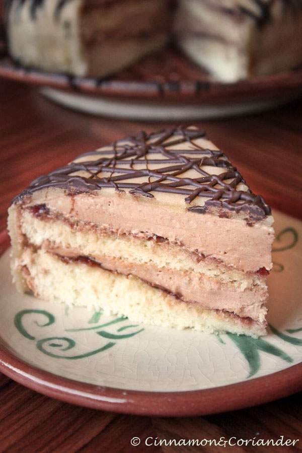 a slice of German Marzipan Hazelnut Cake with Hazelnut Buttercream and Sour Cherry Jam