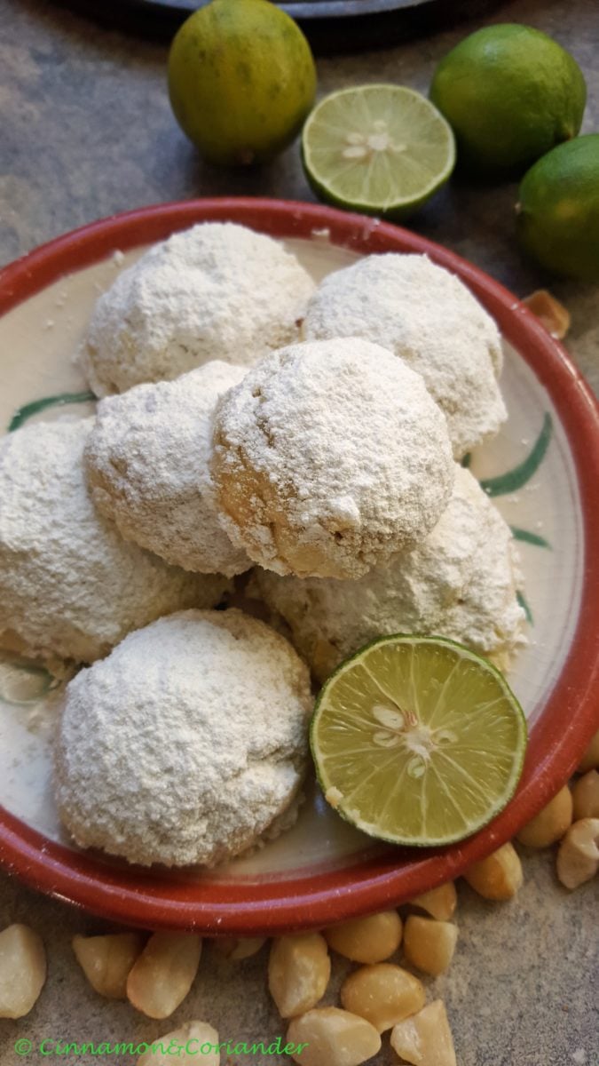 overhead shot of a plate with Mexican Wedding Cookies with Lime and Macadamia Nuts dusted with powdered sugar 