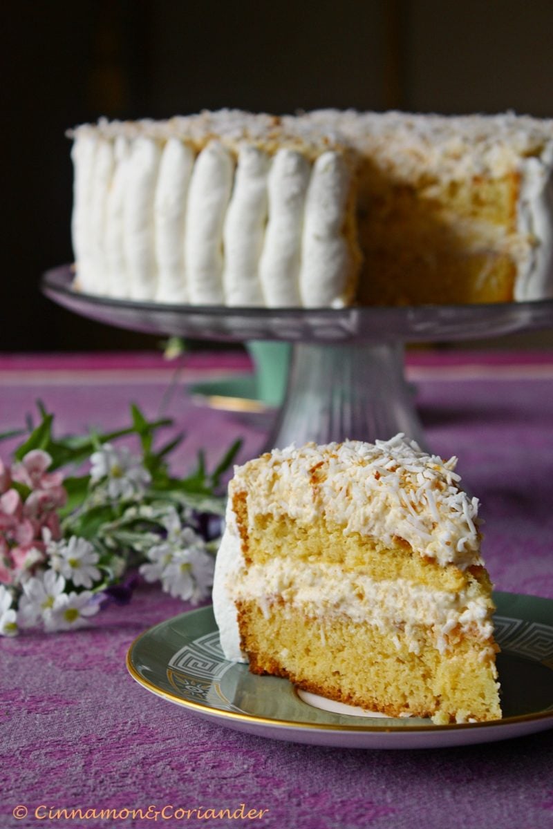 Raffaello Cake with White Cocolate and Advocaat Liqueur on a cake stand with one slice cut