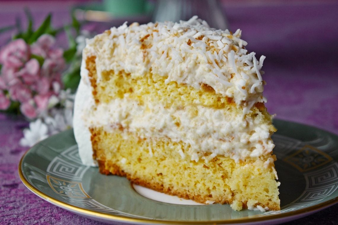 Ein Stück von Omas bester Raffaello Torte mit Eierlikör und weißer Schokolade auf einem Kuchenteller