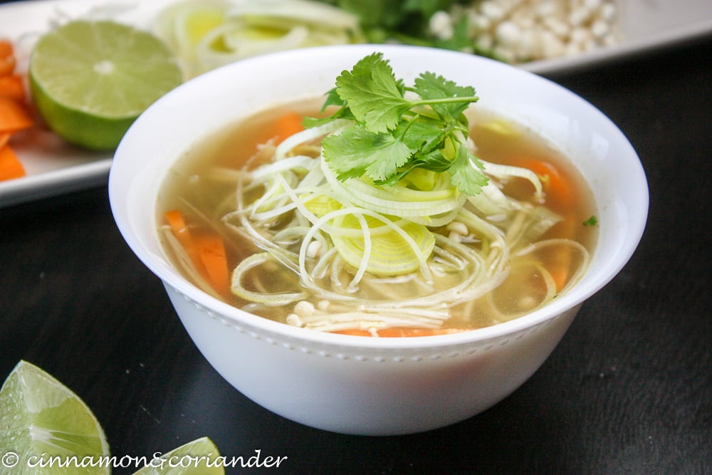 Vegane vietnamesische Nudelsuppe Pho mit Limette und Koriander dekoriert