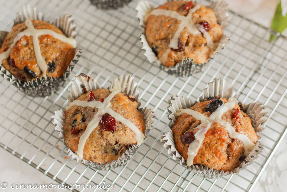 Hot Cross Muffins studded with dried fruit on a cooling rack