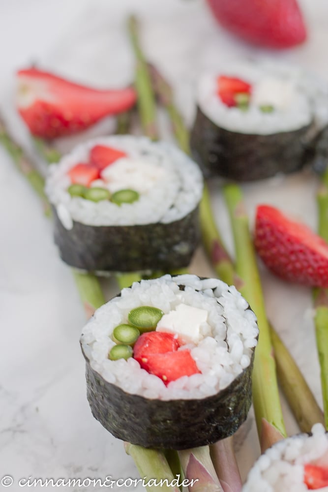 vegetarian sushi rolls with strawberries feta and asparagus on a marble countertop