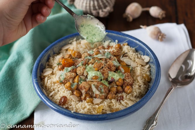 Vegane Tahini Sauce wird auf Couscous Bowl mit gerösteten Kichererbsen und Blumenkohl gegeben