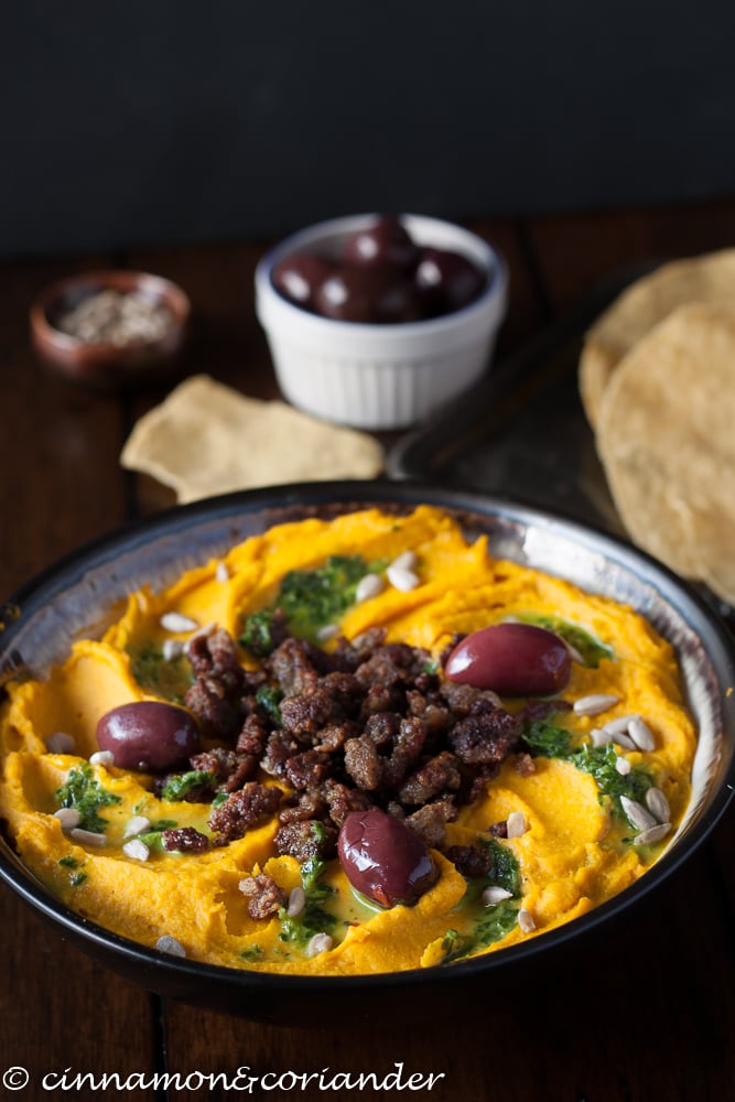 Roasted Kabocha Squash Hummus with minced lamb and lemon parsley sauce served in a black bowl