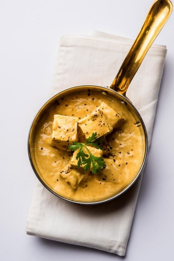 overhead shot of a saucepan with Indian achari paneer masala in yogurt gravy